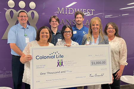 MTN staff holding a large check from Colonial Life