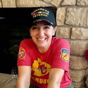 A woman wearing a black ball cap that reads Afghanistan Veteran.
