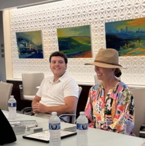 A college-age man and a woman sitting at a conference table.
