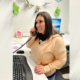 A woman talking on an office phone.