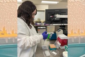 A woman in a lab coat testing samples.
